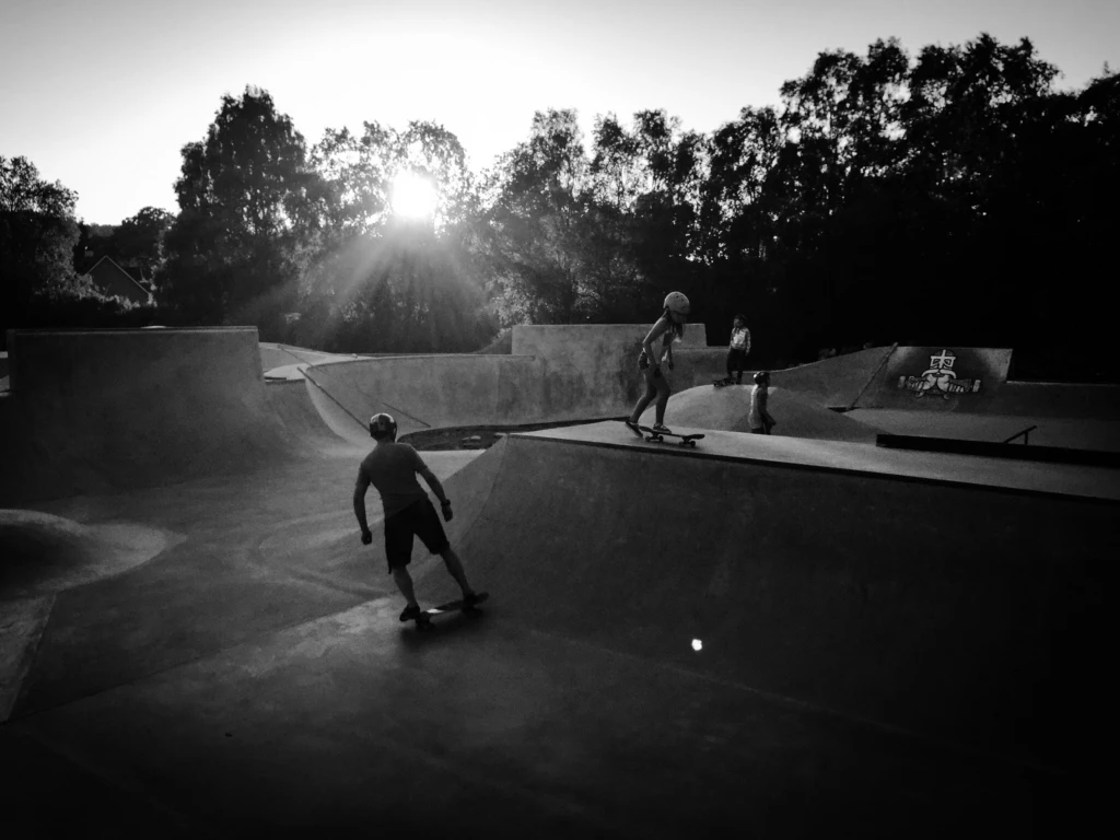 Två personer som skejtar på en skatepark, i svartvitt foto.